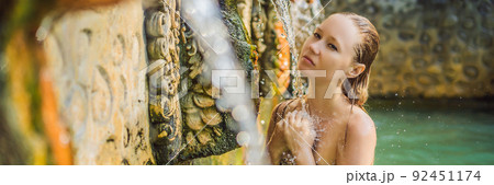 Young woman in hot springs banjar. Thermal water is released from the mouth of statues at a hot springs in Banjar, Bali, Indonesia BANNER, LONG FORMAT Young woman in hot springs banjar. Thermal water is released from the mouth of statues at a hot springs in Banjar, Bali, Indonesia BANNER, LONG FORMAT 92451174