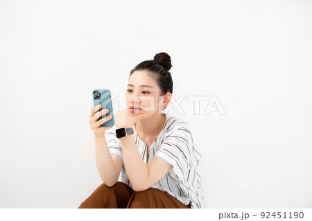 女性　スマホ　お団子ヘア 92451190