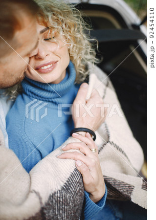 Romantic couple sitting in a trunk of white car in a forest and hugging 92454110