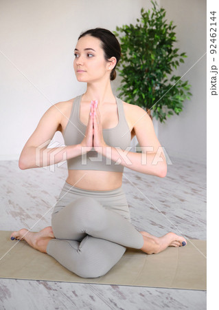 Young woman practices yoga in the studio. The girl meditates outdoors. 92462144