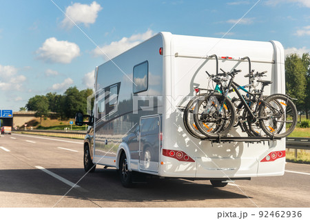 Scenic view big modern white family rv camper van vehicle driving on european highway road against blue sky in summer day. Rving motorhome lifestyle travel and adventure tourism trip journey concept 92462936