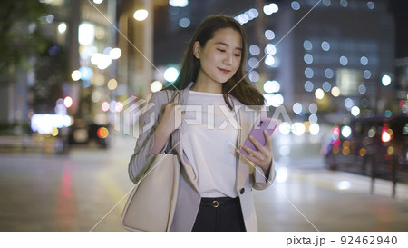 会社帰りにスマホを見るビジネスウーマン 女性 スマートフォン 92462940