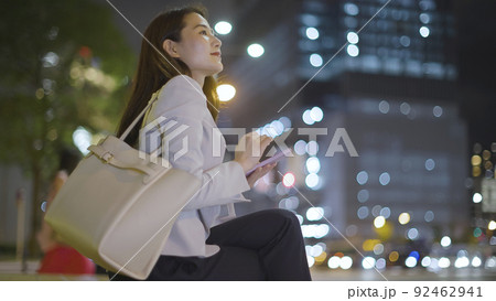 仕事終わりにスマホを見るビジネスウーマン 女性 スマートフォン 92462941