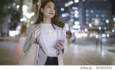 会社帰りにスマホを見るビジネスウーマン 女性 スマートフォン 92462942