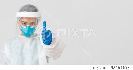 Covid-19, coronavirus disease, healthcare workers concept. Serious-looking confident asian female doctor, physician in personal protective equipment in respirator, show thumbs-up, white background 92464653