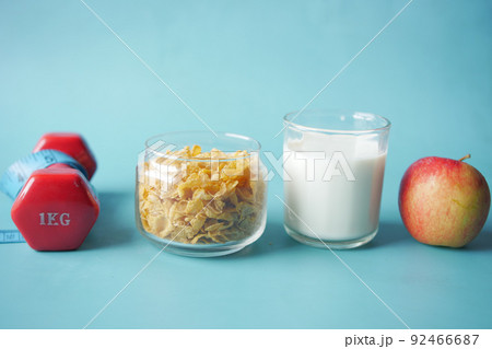 morning cereal , milk, apple and dumbbell on blue morning cereal , milk, apple and dumbbell on blue 92466687