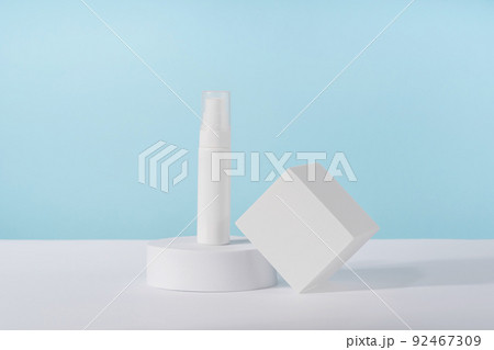 Cosmetic cream bottle mockup on blue background on pedestal podium. Unbranded lotion beauty product packaging. Product presentation mock up. Lotion, cleanser, shampoo for skincare routine 92467309