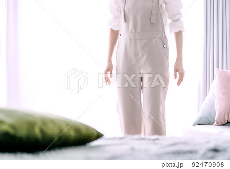 寝室の窓辺に立つ若い女性のイメージカット 92470908