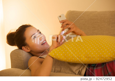 ソファで横たわる女性 92472952