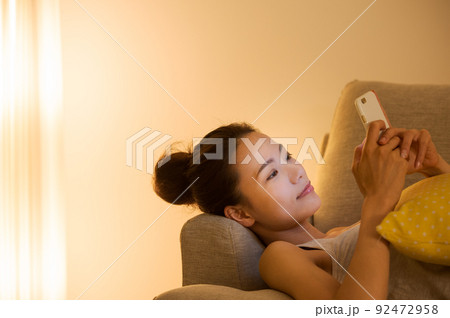 ソファで横たわる女性 92472958