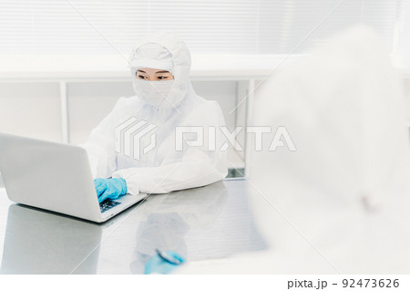 工場のクリーンルームでパソコンを使う作業員の女性 92473626