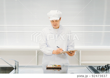 食品を見て分析・評価する調理員・商品開発の男性 92473637