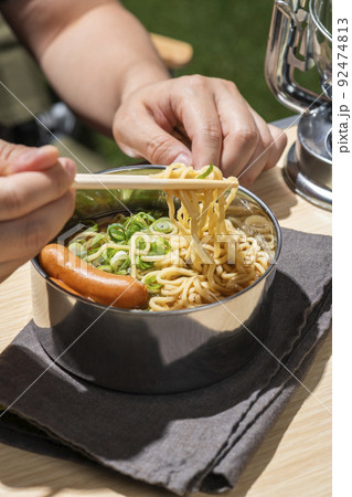 キャンプでインスタントラーメンを食べる男性 92474813