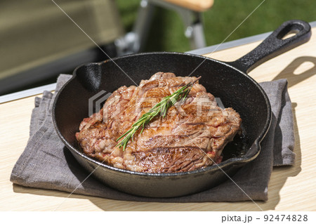 スキレット鍋で調理したステーキ肉のキャンプ飯 92474828