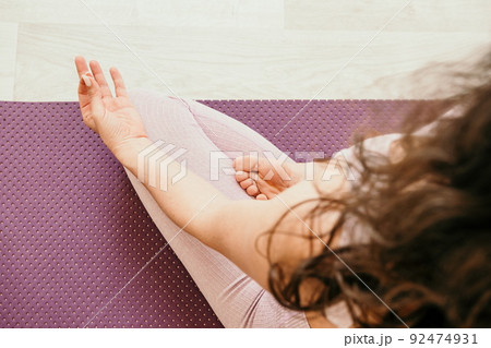young sporty woman, fitness instructor in pink sportswear doing stretching and pilates on yoga mat in the studio with mirror. Female fitness yoga routine concept. Healthy lifestyle and harmony. 92474931