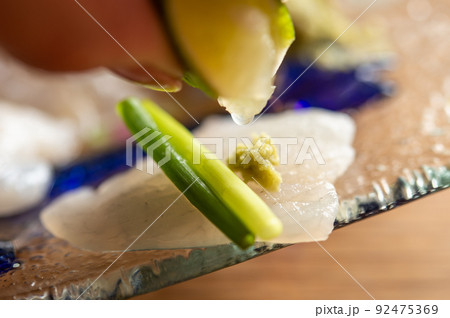 平目のお刺身にライムを絞る 92475369