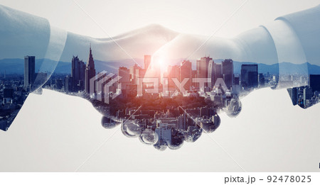 握手するビジネスマンと都市　バナー・広告向け横長ビジュアル 92478025