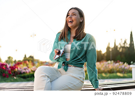 Young woman using a smartphone in the park Young woman using a smartphone in the park 92478809