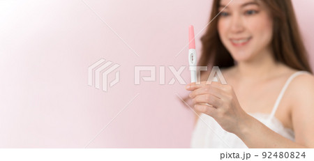 happy pregnant woman holding and showing positive pregnancy test happy pregnant woman holding and showing positive pregnancy test 92480824