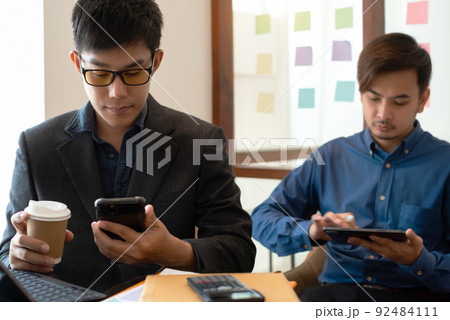 Asian young business people discussing on performance revenue in meeting. businessman working with co-worker team. financial adviser analyzing data with investor. Asian young business people discussing on performance revenue in meeting. businessman working with co-worker team. financial adviser analyzing data with investor. 92484111