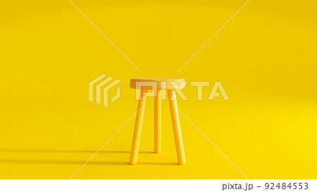 Yellow three legged chair on yellow background light from the side. 92484553