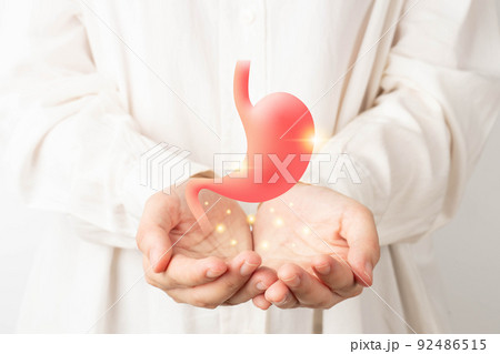 Healthy stomach organ hologram on human hands. Concept of gastric cancer screening, stomach transplant, digestive tract problem and stomach disease treatment. 92486515