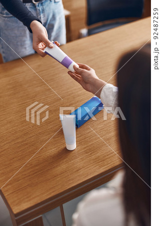 Happy woman is taking a toothpaste from hands of clinic personal Happy woman is taking a toothpaste from hands of clinic personal 92487259