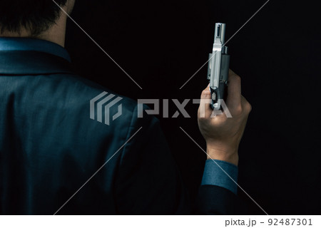 拳銃を構えるスーツの人物 92487301