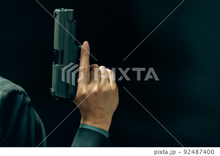 拳銃を構えるスーツの人物 拳銃を構えるスーツの人物 92487400
