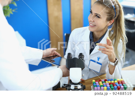 Physician scientists colleagues smile and communicate in laboratory 92488519