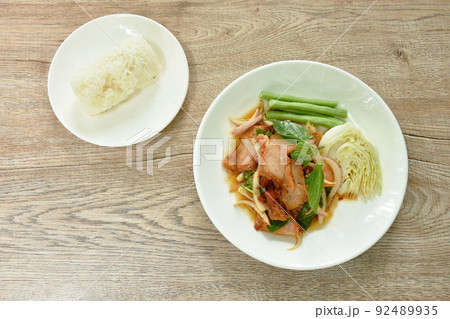 Thai spicy slice barbecue pork neck salad eat couple fresh cabbage and yard long bean on plate with sticky rice Thai spicy slice barbecue pork neck salad eat couple fresh cabbage and yard long bean on plate with sticky rice 92489935