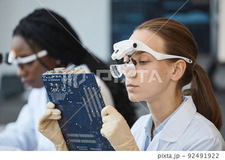 Female Engineer Inspecting Tech Parts 92491922