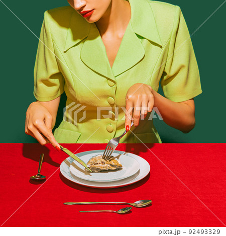 Cropped image of woman eating oyster on red tablecloth isolated over green background. Delicious taste Cropped image of woman eating oyster on red tablecloth isolated over green background. Delicious taste 92493329
