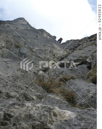 Climber at Kaiser Max via ferrata in Tyrol, Austria Climber at Kaiser Max via ferrata in Tyrol, Austria 92493613
