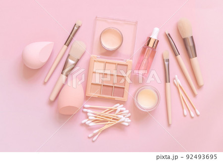 Natural beige eye shadow and decorative cosmetics on light pink, top view Natural beige eye shadow and decorative cosmetics on light pink, top view 92493695