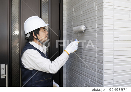 刷毛で戸建て住宅の外壁を塗る塗装職人 92493974