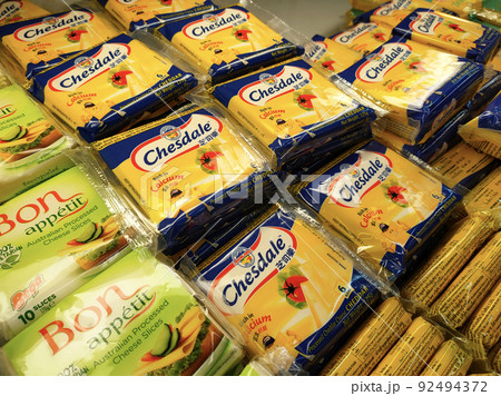 SELANGOR, MALAYSIA -12 APRIL 2022: Sliced cheese placed in commercial packs and displayed for sale. Each pack has several slices of cheese. Separated by brand, type and flavor. SELANGOR, MALAYSIA -12 APRIL 2022: Sliced cheese placed in commercial packs and displayed for sale. Each pack has several slices of cheese. Separated by brand, type and flavor. 92494372