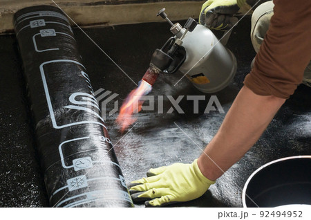 installation of waterproofing coating on the floor with a blowtorch and resin. installation of waterproofing coating on the floor with a blowtorch and resin. 92494952
