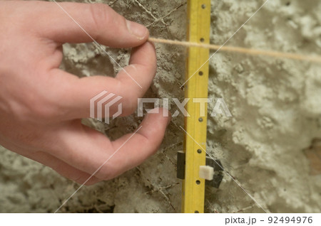 Metal guides for plastering walls, installation of metal beacons on the wall. 92494976