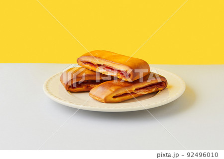 Lanche misto traditional portuguese sandwich with cheese and chorizo. Tasty breakfast over yellow background. 92496010