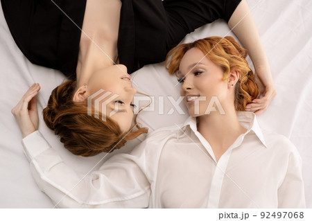 business over bed - Stylish young businesswomen lying in black and white cloth - top view 92497068