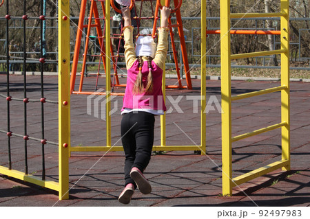 Children on a sunny day play in the playground, equipped with sports equipment.. Children on a sunny day play in the playground, equipped with sports equipment.. 92497983