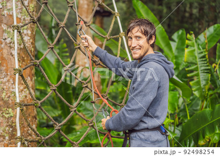 strong young men in a rope park on the wood background 92498254