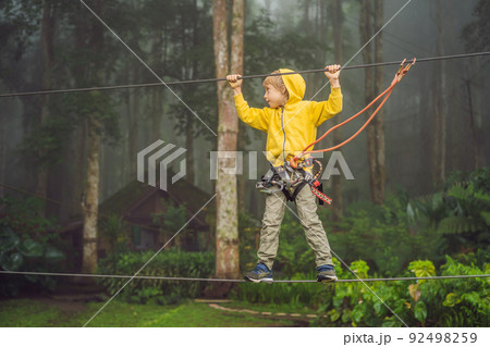 Little boy in a rope park. Active physical recreation of the child in the fresh air in the park. Training for children 92498259