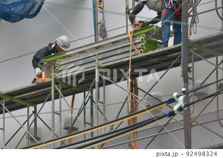工事現場　とび職人　流通倉庫の仮設足場撤去作業風景 92498324