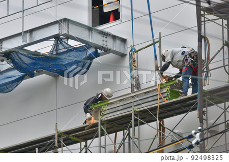 工事現場　とび職人　流通倉庫の仮設足場撤去作業風景 92498325