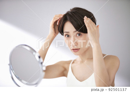 髪の毛を気にするミドル女性 92501137