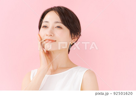 スキンケアをする女性　ピンク背景 92501620