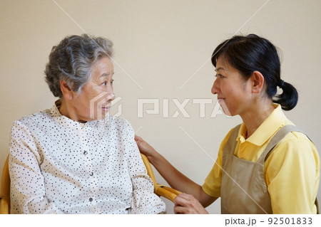 仲良く会話する高齢女性と中年女性　介護イメージ 92501833
