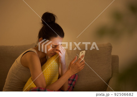 ソファでスマホを見る女性 ソファでスマホを見る女性 92506682